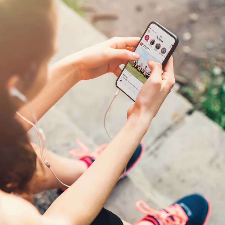 Woman in workout gear on Instagram app viewing the My Muscle Chef profile