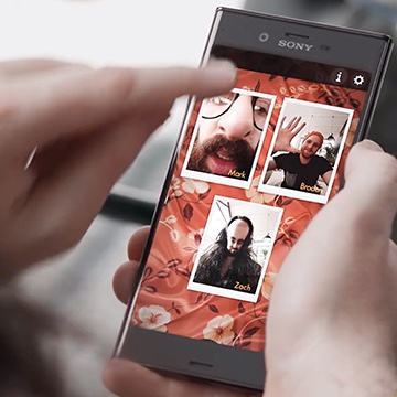 Sony phone using the Playstation app with three friends playing a game