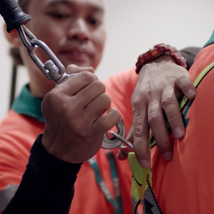 Photograph of Toll employee practicing safety by harnessing another employee